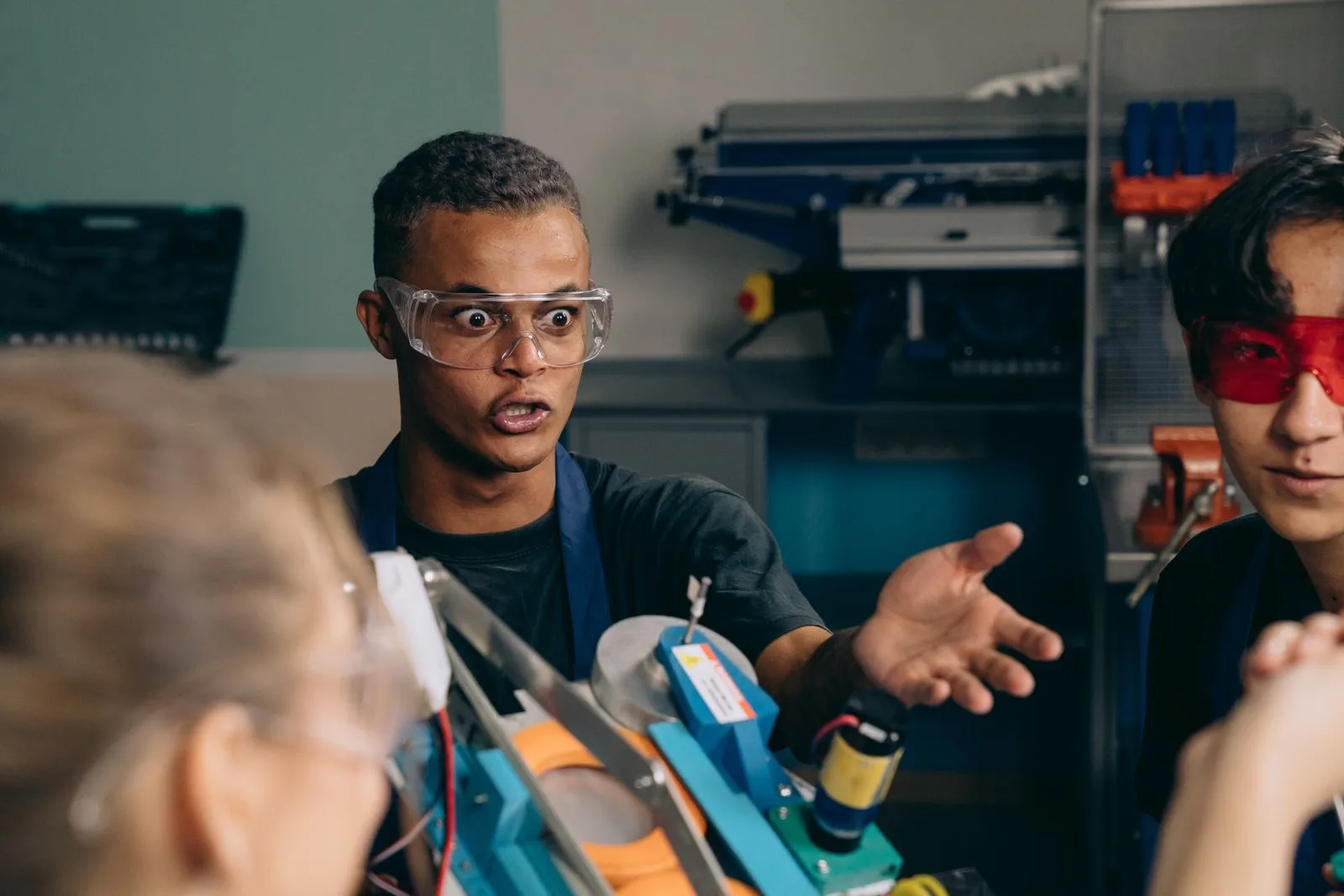 Tutor explaining a circuit build to students in a hands-on electronics lab