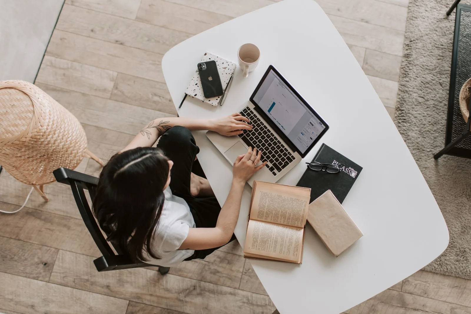 What is College Application Essays - student drafting and refining essay work on a laptop with reference books