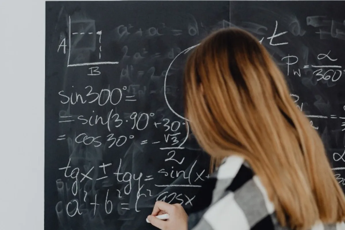 What is high school math - student solving geometry and trig formulas at the board