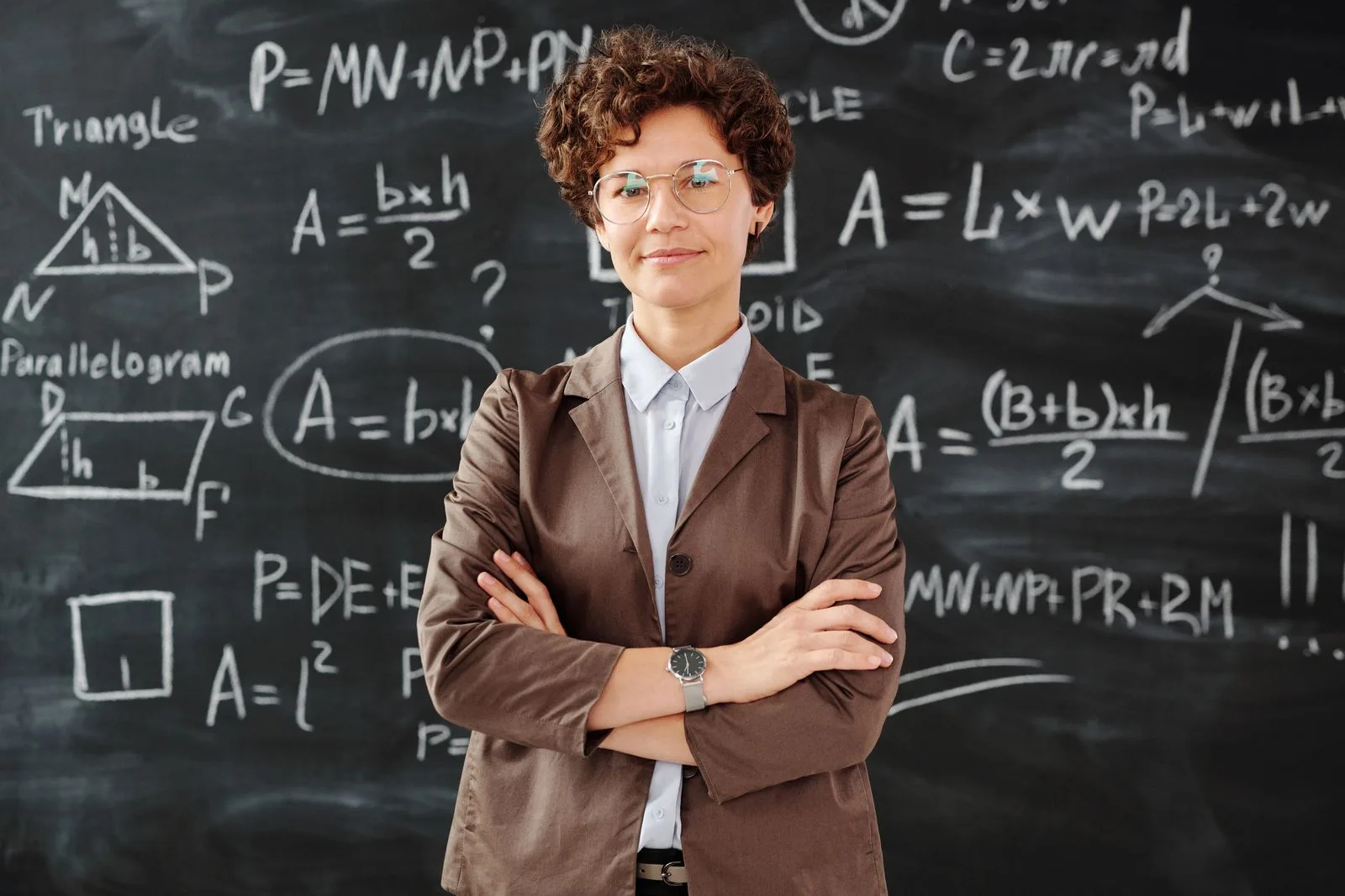 Qualified pre-algebra tutors - expert teacher with geometry and area formulas on a chalkboard